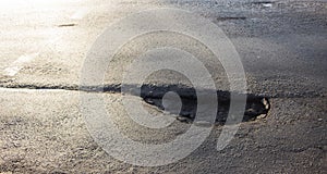 Waterfilled pothole on asphalted road