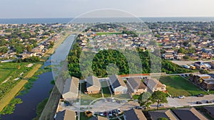 Waterfront Lake Pontchartrain neighborhood with row of townhomes, two-story single-family house, apartment complex along Farrar