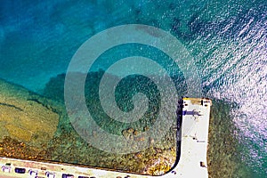 Waterfront port Mandraki Rhodes island, clear turquoise water, rocks and bottom in clear water, top view, bird`s eye