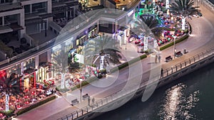 Waterfront promenade in Dubai Marina aerial night timelapse. Dubai, United Arab Emirates