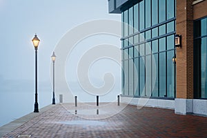 The Waterfront Promenade in fog and a modern building in Fells Point, Baltimore, Maryland