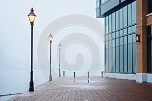 The Waterfront Promenade in fog and a modern building in Fells Point, Baltimore, Maryland