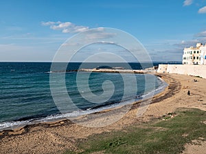 Waterfront and sandy beach at sunny Gallipoli, Italy and Seno della Purita bay at sunset photo