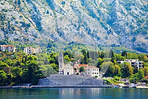 Waterfront of small town Dobrota along Bay of Kotor, Montenegro. View of Church of St Mathew, coastal villas, gardens and mountain