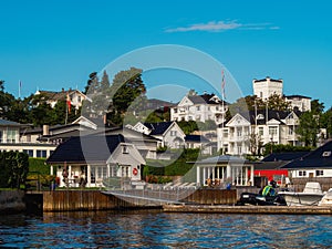 Waterfront view on a white houses on a shore in Oslo fjord. Norwegian detached houses