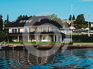 Waterfront view on a white houses on a shore in Oslo fjord. Norwegian detached houses