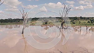 Waterhole lake in Laikipia, Kenya. Aerial drone moving backwards of Kenyan landscape scene