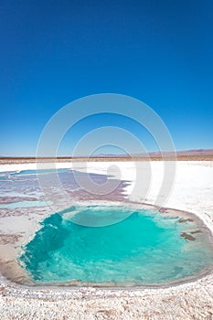 A waterhole with salt around it in blue sky day - amazing colors photo