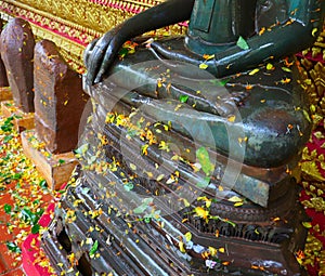 Watering Buddha statues with scented water and flower petals during Lao New Year