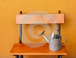 A watering-can aluminium laid on a wooden bench