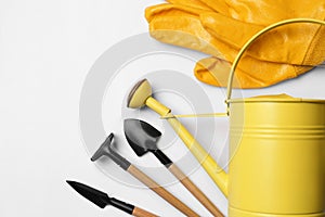 Watering can, gardening tools and gloves on white background, flat lay