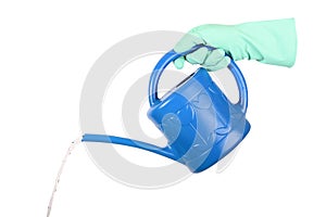 Watering can in hand. A rubber gloved hand pours water from a plastic watering can. Isolated on white with saved path.