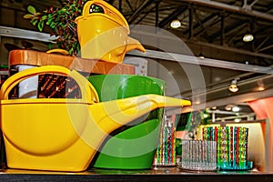 Watering can Plastic products, plant care items on the supermarket showcase. Replacing disposable tableware