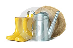 Watering can, rubber boots and straw hat isolated on white background