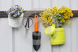 watering can and spatula for planting in the garden with a bouquet of flowers.