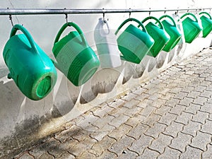 Watering cans hanging in a row photo