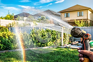 Watering the grass, garden, rainbow created by the water and light