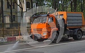 Watering machine washes the street