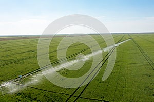 Watering system in the field. An irrigation pivot watering a field.