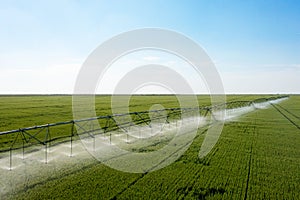 Watering system in the field. An irrigation pivot watering a field.