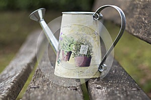 Watering vintage can on a wooden bench