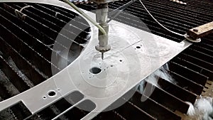 CNC Waterjet cuts stainless steel sheet - closeup photo