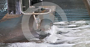 Waterjet metal cutting. Hydroabrasive high pressure CNC machine is cutting metal