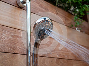 Waterjets flowing out of handheld shower head in outdoor shower
