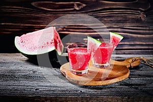 Watermelon cocktail on a dark wooden table.