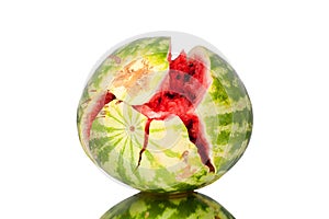 Watermelon with cracks on white mirror background with reflection isolated close up