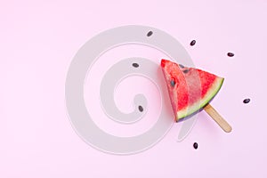 Watermelon fruit sliced with wood ice cream stick on pink background