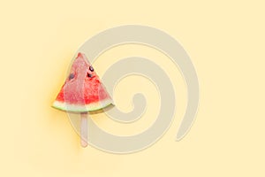 Watermelon fruit sliced with wood ice cream stick on yellow background