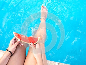 Watermelon in the hand of a girl in swimming pool