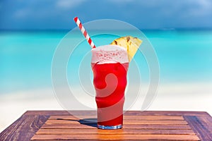 Watermelon Ice Cream Soda Float cocktail with straw on wooden table with ocean background at the beach