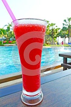 Watermelon juicy in a glass beside swimming pool