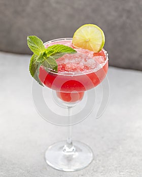 Watermelon margarita cocktail with lime. Watermelon summer cocktail with ice and mint leaves.