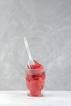 Watermelon pieces in disposable plastic cup with fork