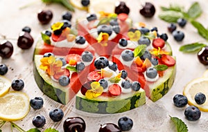 Watermelon pizza with addition of fersh blueberries, strawberries, natural yogurt and edible flowers