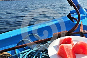 Watermelon and rusty anchor on blue boat in Khasab Oman