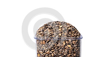 Watermelon seeds in a transparent glass on an isolated white background