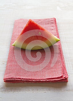 Watermelon slice on pink napkin placemat