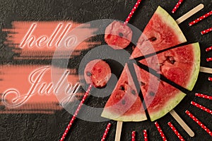 Watermelon slice with text Hello July, on dark background