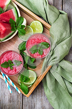 Watermelon slices and drink on a rustic wooden table