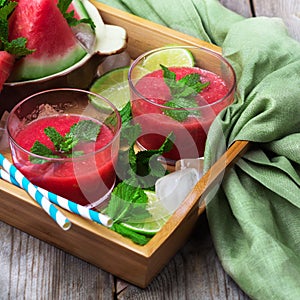 Watermelon slices and drink on a rustic wooden table