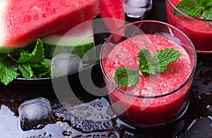 Watermelon slices drink smoothie with mint on grunge table