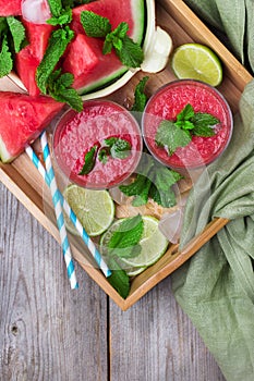 Watermelon slices and drink smoothie on rustic wooden table