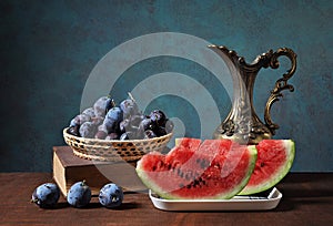 Watermelon slices and plums in wickerbasket