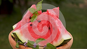 Watermelon slices on wooden plate rotate