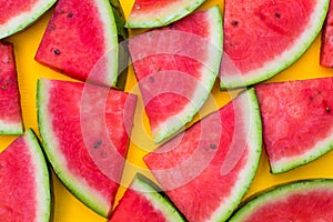 Watermelon slices on yellow background, summer fruit concept