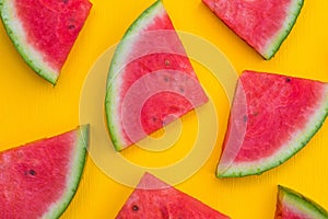 Watermelon slices on yellow background, summer fruit concept